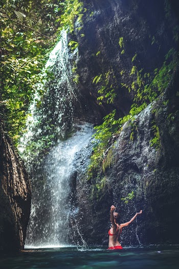 Woman Wearing Red Bikini Under Waterfalls