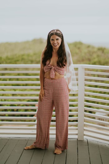 Woman Wearing Red Checked Crop Top With High-waist Pants Standing in Front White Fence