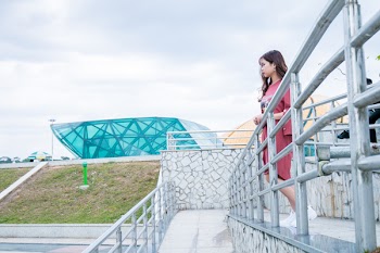 Woman Wearing Red Crew-neck Dress Near Gray Wall