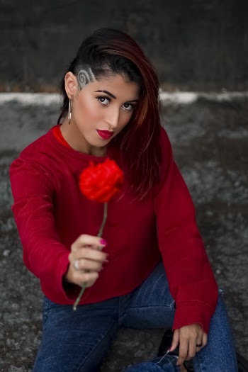 Woman Wearing Red Crew Neck Long Sleeve Shirt Sitting And Holding Red Rose Flower