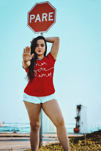 Woman Wearing Red Crew-neck Shirt and White Denim Shorts Doing Stop Hand Sign