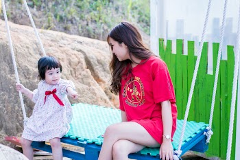 Woman Wearing Red Crew-neck Shirt Sitting on Swing Bench