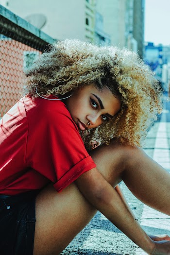 Woman Wearing Red Crew-neck T-shirt and Black Shorts Sitting on Floor