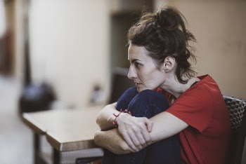 Woman Wearing Red Crew-neck T-shirt Sitting Near the Table