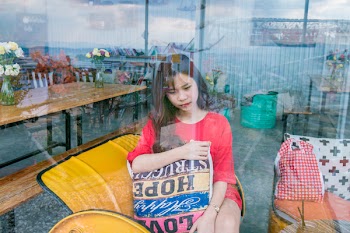 Woman Wearing Red Crew-neck T-shirt Sitting on Yellow Sofa Chair