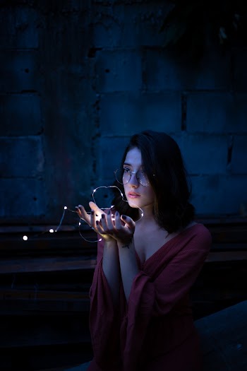 Woman Wearing Red Dress Holding Turned-on String Lights