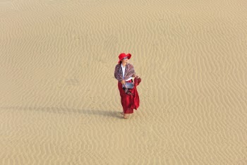 Woman Wearing Red Dress Walking on Empty Desert