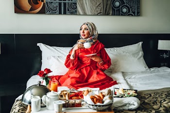 Woman Wearing Red Gown Holding White Ceramic Cup and Saucer