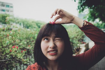 Woman Wearing Red Long-sleeved Shirt With Red Petaled Flower on Head