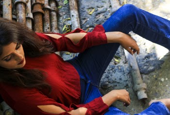 Woman Wearing Red Long-sleeved Top Sitting on Pile of Metal Pipes