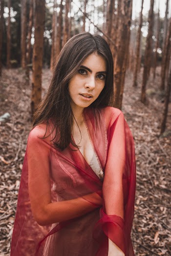Woman Wearing Red Mesh Scarf Across Woods