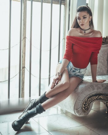 Woman Wearing Red Off-shoulder Top and Blue Denim Shirts Sitting on Lounge