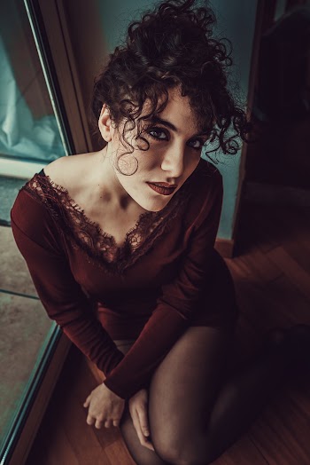 Woman Wearing Red Plunging-neck Long-sleeved Mini Dress Sitting on Floor