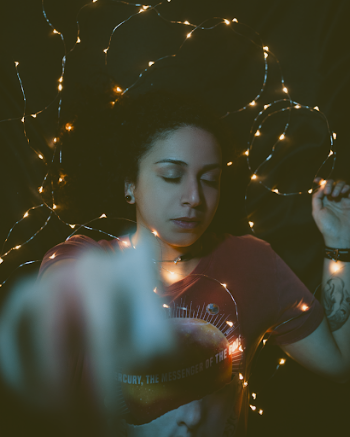 Woman Wearing Red Shirt Covered in String Lights