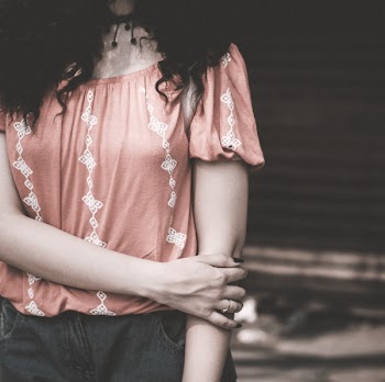 Woman Wearing Red Shirt Holding Elbow
