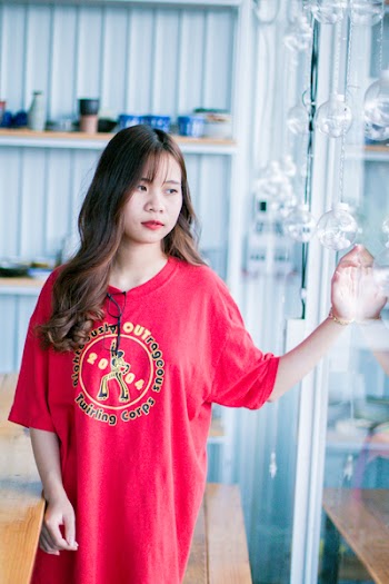 Woman Wearing Red Shirt Standing Near Glass Hanging Decor