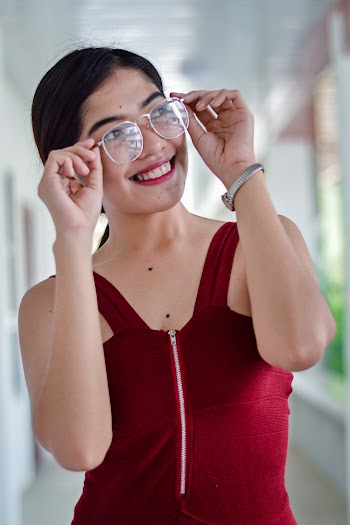 Woman Wearing Red Sleeveless Top While Holding Her Eyeglasses