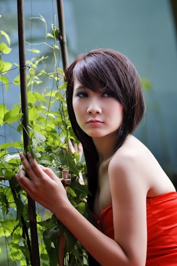 Woman Wearing Red Strapless Top Beside Green Leafed Plants