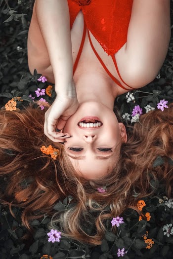 Woman Wearing Red Tank Top Lying on Leaves