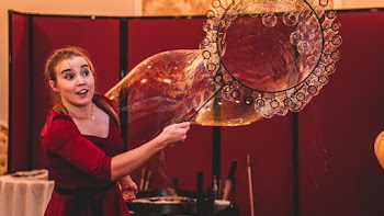Woman Wearing Red Top Making Giant Bubble