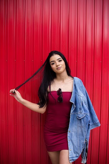 Woman Wearing Red Tube Dress Standing and Holding Strands of Her Hair