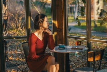 Woman Wearing Red V-neck Long-sleeved Dress Sitting on Chair