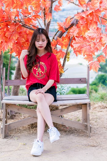 Woman Wearing Red V-neck Shirt Sitting Near Red Leafed Tree