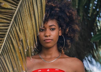 Woman Wearing Silver-colored Hoop Earrings and Necklace Behind Green Palm Tree Leaf