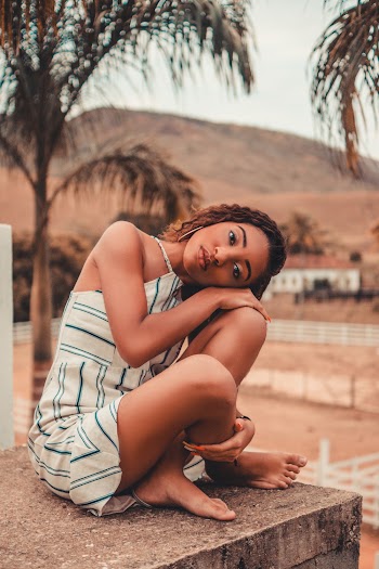 Woman Wearing Spaghetti Strap Dress While Sitting on Concrete Surface