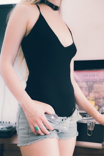 Woman Wearing Spaghetti Strap Top, Choker Necklace, and Gray Denim Short Shorts With Open Zipper and Button