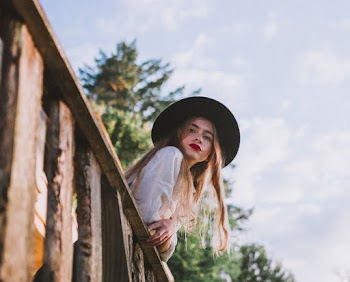 Woman Wearing Sun Hat Leaning on Wooden Railing