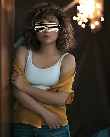 Woman Wearing Sunglasses Leaning on Wall