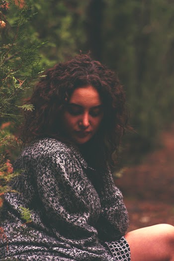 Woman Wearing Sweater Leaning on Green Tree