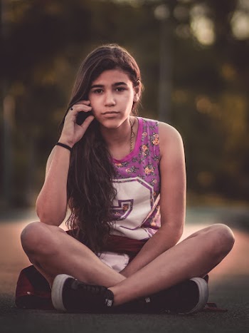 Woman Wearing Tank Top Sitting on Road