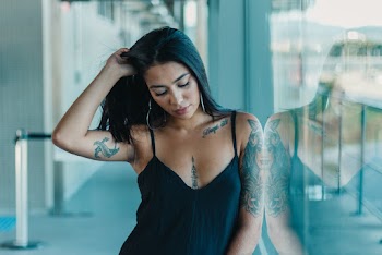 Woman Wearing Tank Top Standing Next to Glass Wall
