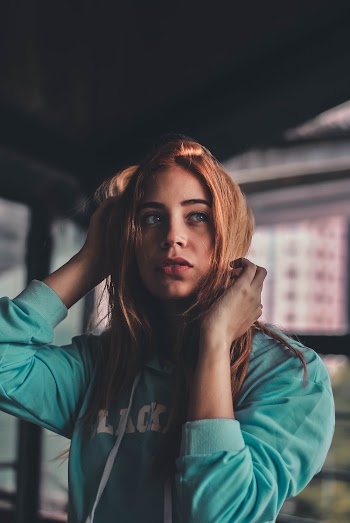 Woman Wearing Teal Sweatshirt Near Building Outdoors