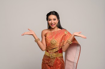 Woman wearing thai dress that made a hand symbol Free Photo