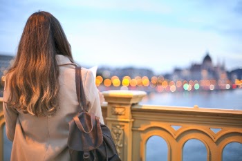Woman Wearing Trench Coat And Black Leather Backpack