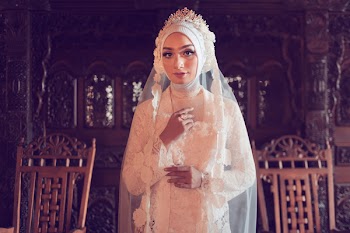 Woman Wearing White Abaya Wedding Dress Behind Brown Chairs