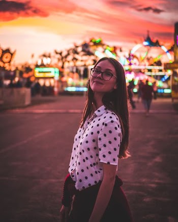 woman wearing white and black polka-dot button-up shirt in shallow focus photography