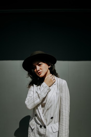 Woman Wearing White and Black Striped Blazer and Hat