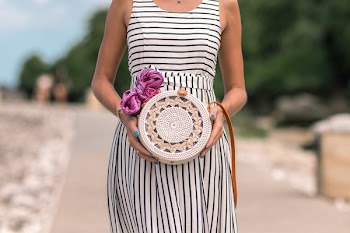 Woman Wearing White And Black Striped Sleeveless Dress Holding Round Crochet Bag