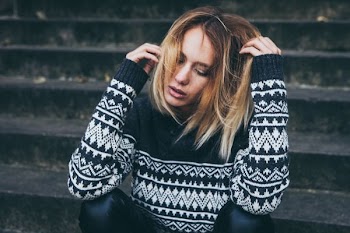 woman wearing white and black sweater sitting on stair