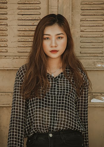 Woman Wearing White and Black Tattersall Collared Button-up Blouse Standing Near Brown Wall