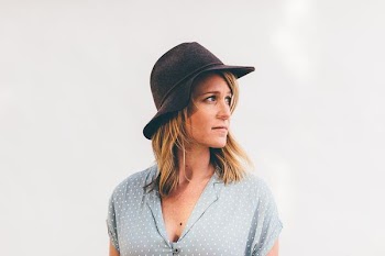 woman wearing white and blue polka-dot button-up cap-sleeved shirt