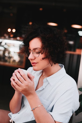 Woman Wearing White And Blue Stripe Button-up Top Holding White Cup
