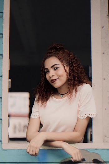 Woman Wearing White Blouse Leaning on Window Pane