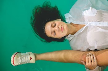 woman wearing white button-up dress shirt soaking in body of water