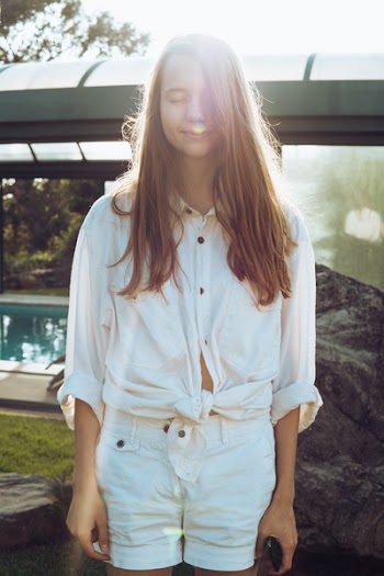 Woman Wearing White Button-up Long-sleeved Shirt and White Shorts Standing Near Swimming Pool