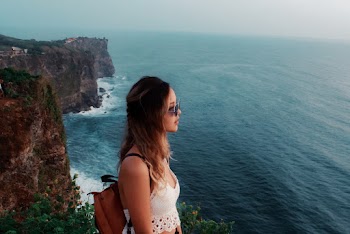 Woman Wearing White Cami Crop-top Standing on Rock Formation Near Body of Water